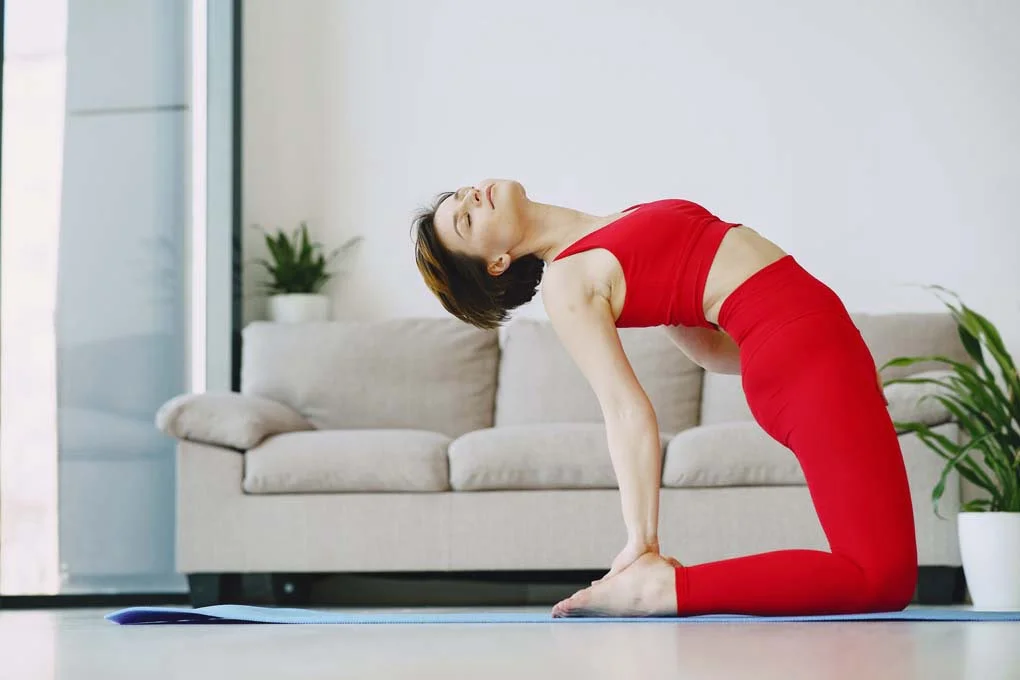 relaxed-young-barefoot-woman-practicing-yoga-in-camel-pose